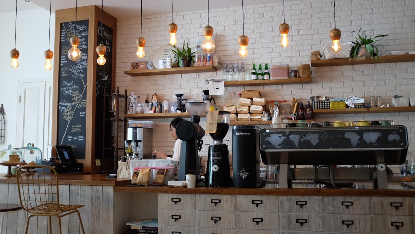 La barra de una cafetería con la máquina de espresso y la pizarra de la carta